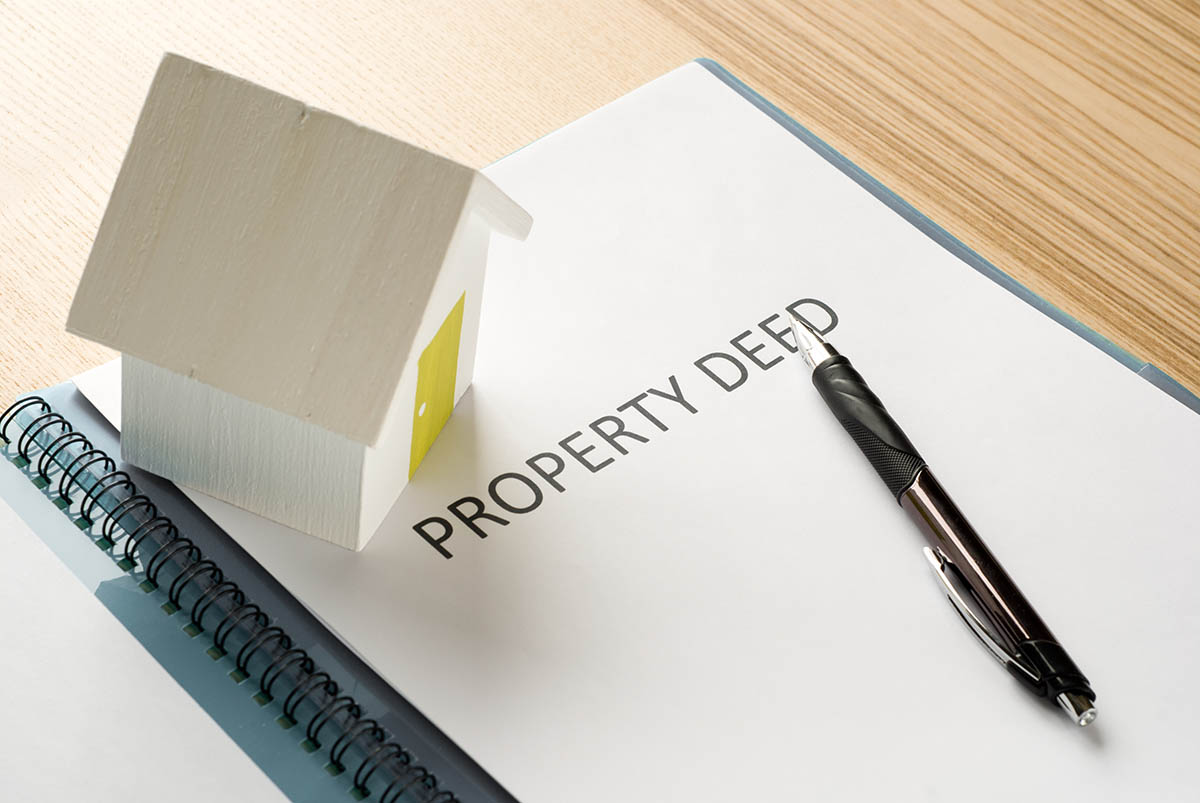 Property deed and keys on a desk
