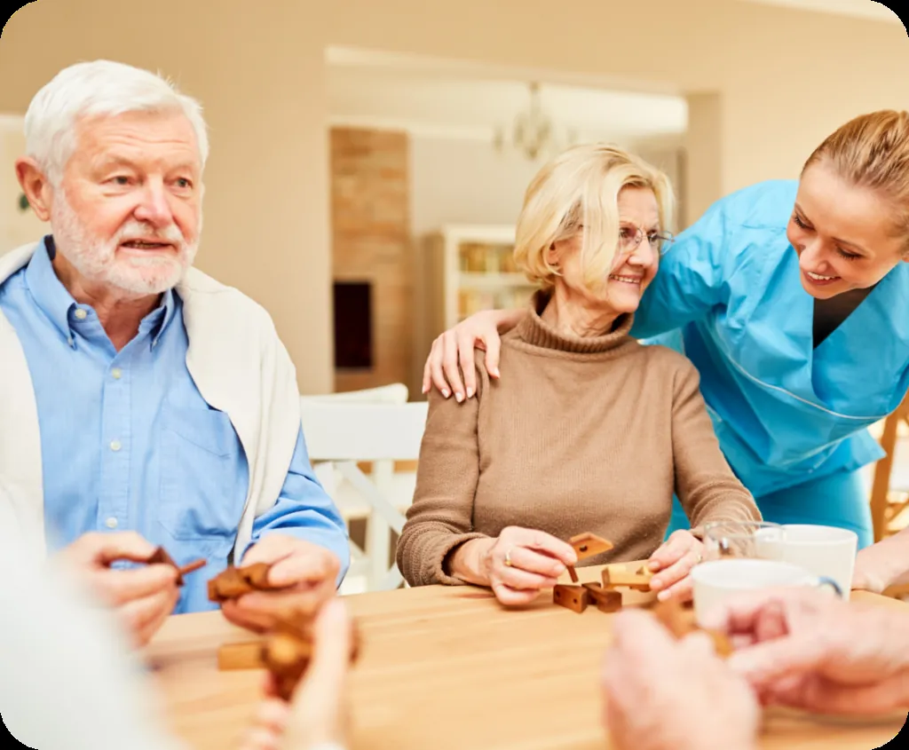 Caregiver helping an older couple with a table activity at home